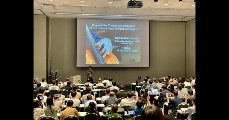 Dr. Su presenting on regenerative therapy and ultrasound-guided interventions for the hand to a large conference audience